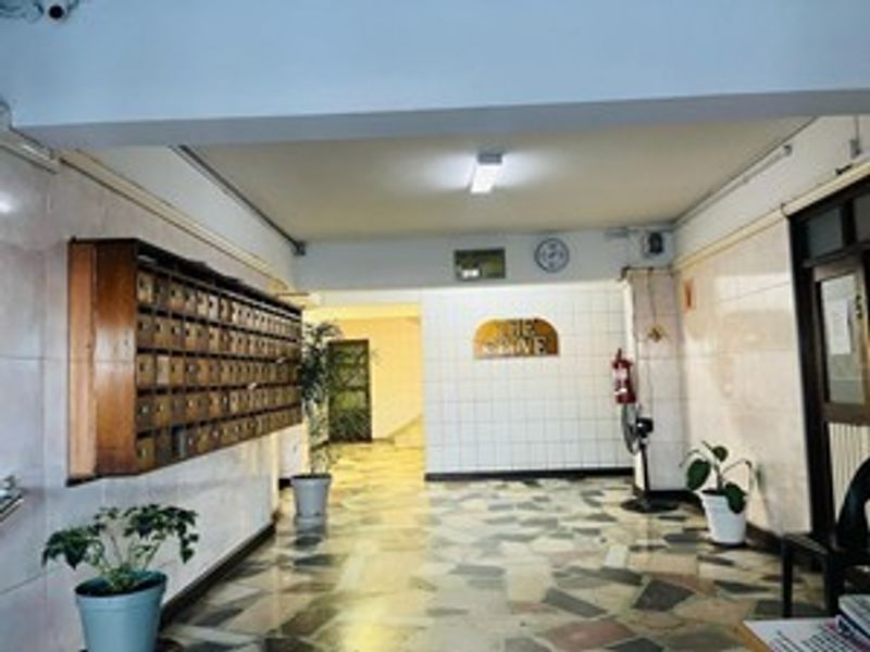 Apartment building entrance lobby featuring tiled flooring, wall-mounted mailboxes, and a functional layout with access to the main building interior.