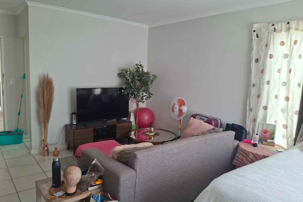 A living room area featuring tiled flooring and neutral wall finishes, providing a functional space for relaxation and daily living.