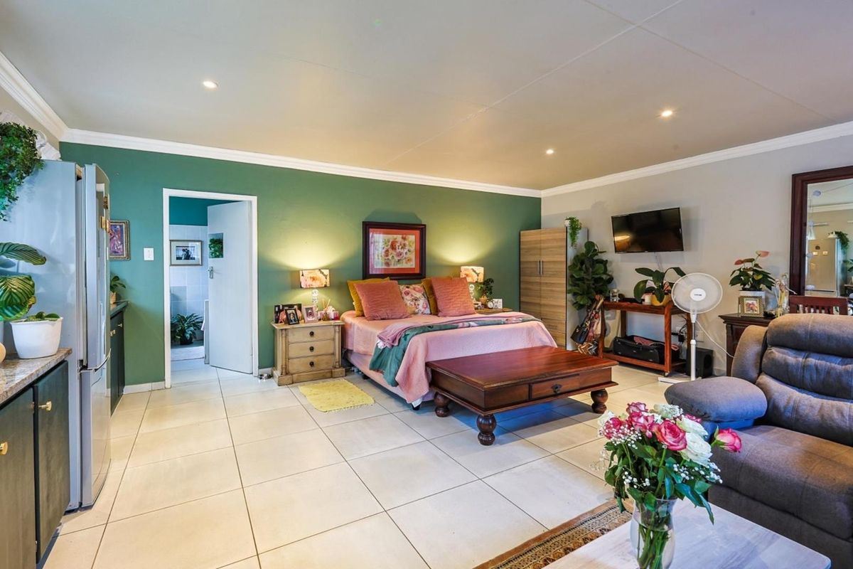 Spacious bedroom featuring tiled flooring, recessed ceiling lighting, and an en-suite bathroom access point.