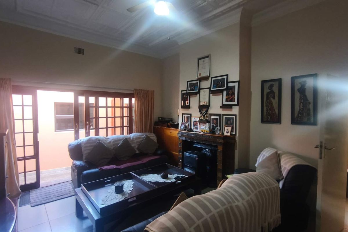 A living room featuring a fireplace, tiled flooring, and sliding glass doors providing access to an outdoor area.