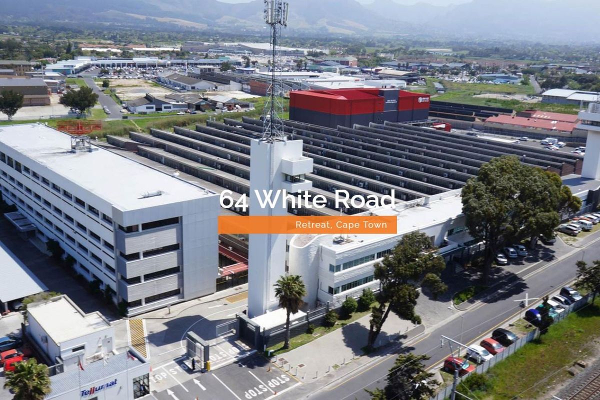 Aerial view of a large industrial property in Retreat, Cape Town, featuring a multi-story office building, warehouse facilities, and a telecommunications tower.