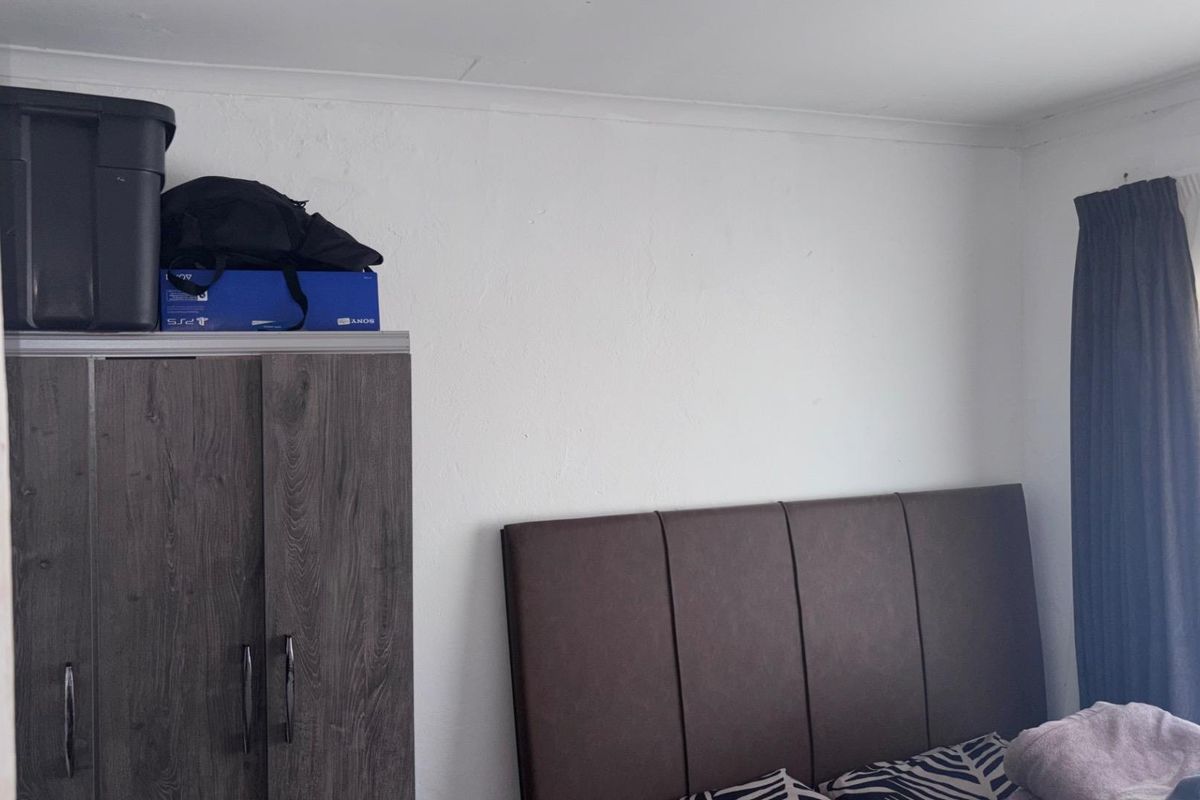 A bedroom featuring a built-in wardrobe and coving, providing a functional space with standard finishes.
