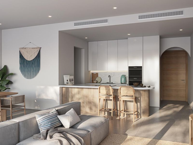 Modern open-plan living area featuring a sleek kitchen with integrated appliances, stone countertops, and a breakfast bar, seamlessly flowing into the dining and lounge space.