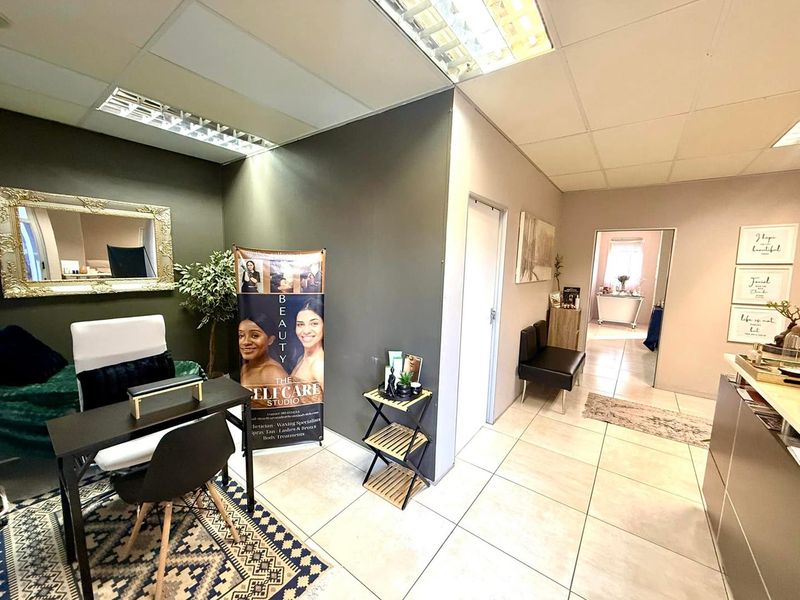 A functional office or studio space featuring tiled flooring, suspended ceiling with recessed lighting, and neutral wall finishes.
