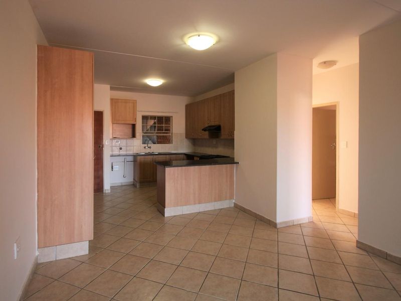 Open plan kitchen featuring laminate cabinetry, granite countertops, and ceramic floor tiles, offering a functional layout for modern living.