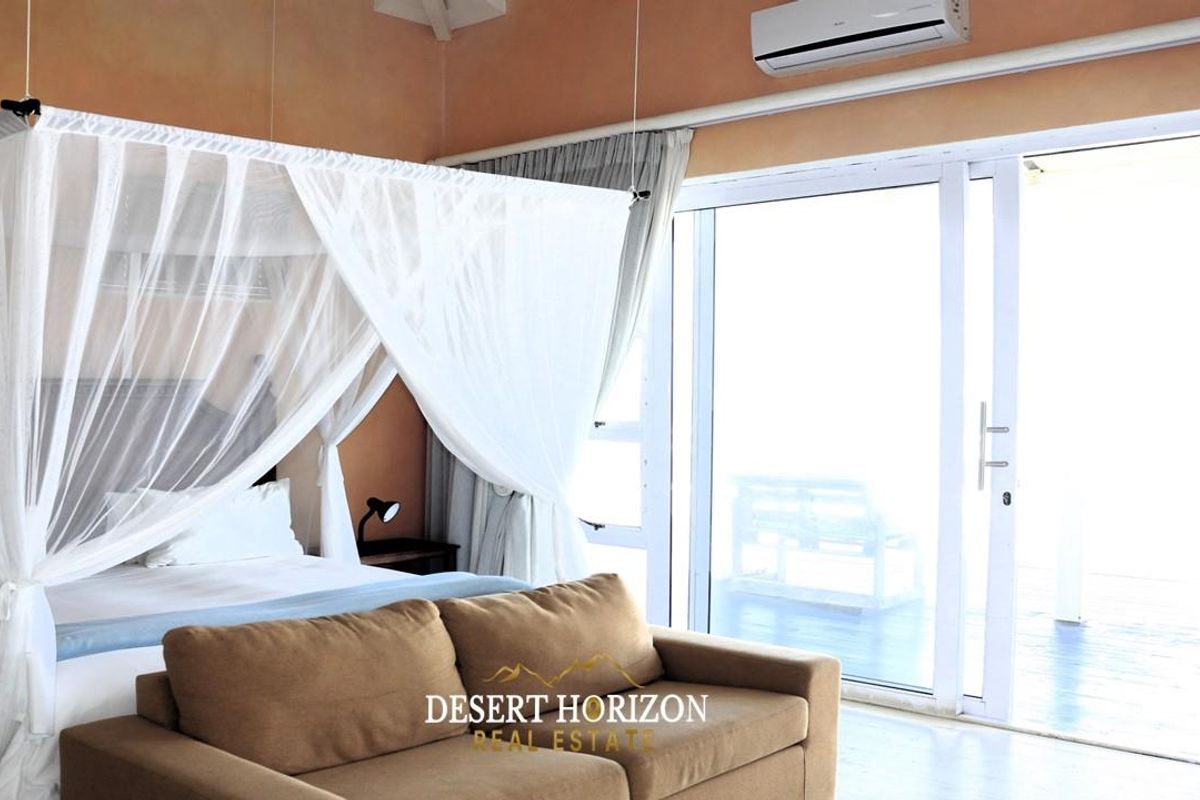 Spacious bedroom featuring high ceilings, split-system air conditioning, and large sliding glass doors providing seamless access to an outdoor area.