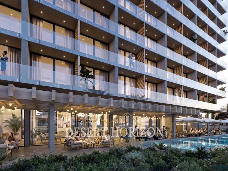 Modern hotel exterior featuring a swimming pool, timber pergola, and multi-story building with glass-fronted balconies.