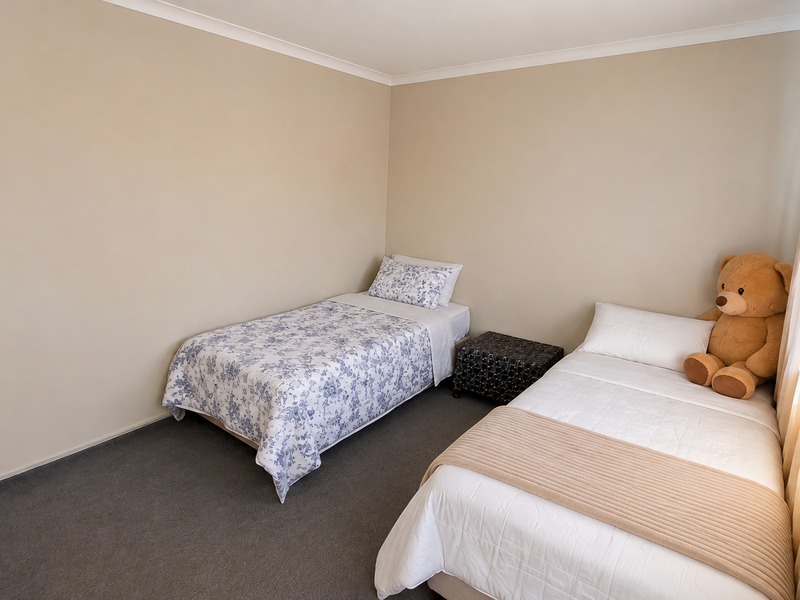 A functional bedroom featuring neutral wall tones, carpeted flooring, and coved cornicing, providing a clean and simple space.