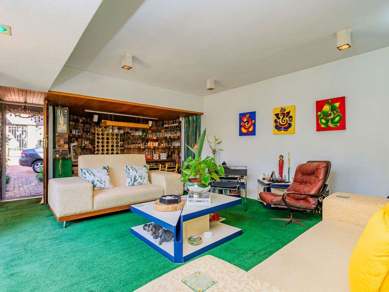 Spacious living room featuring a built-in bar area, recessed lighting, and direct access to the exterior through a sliding door.