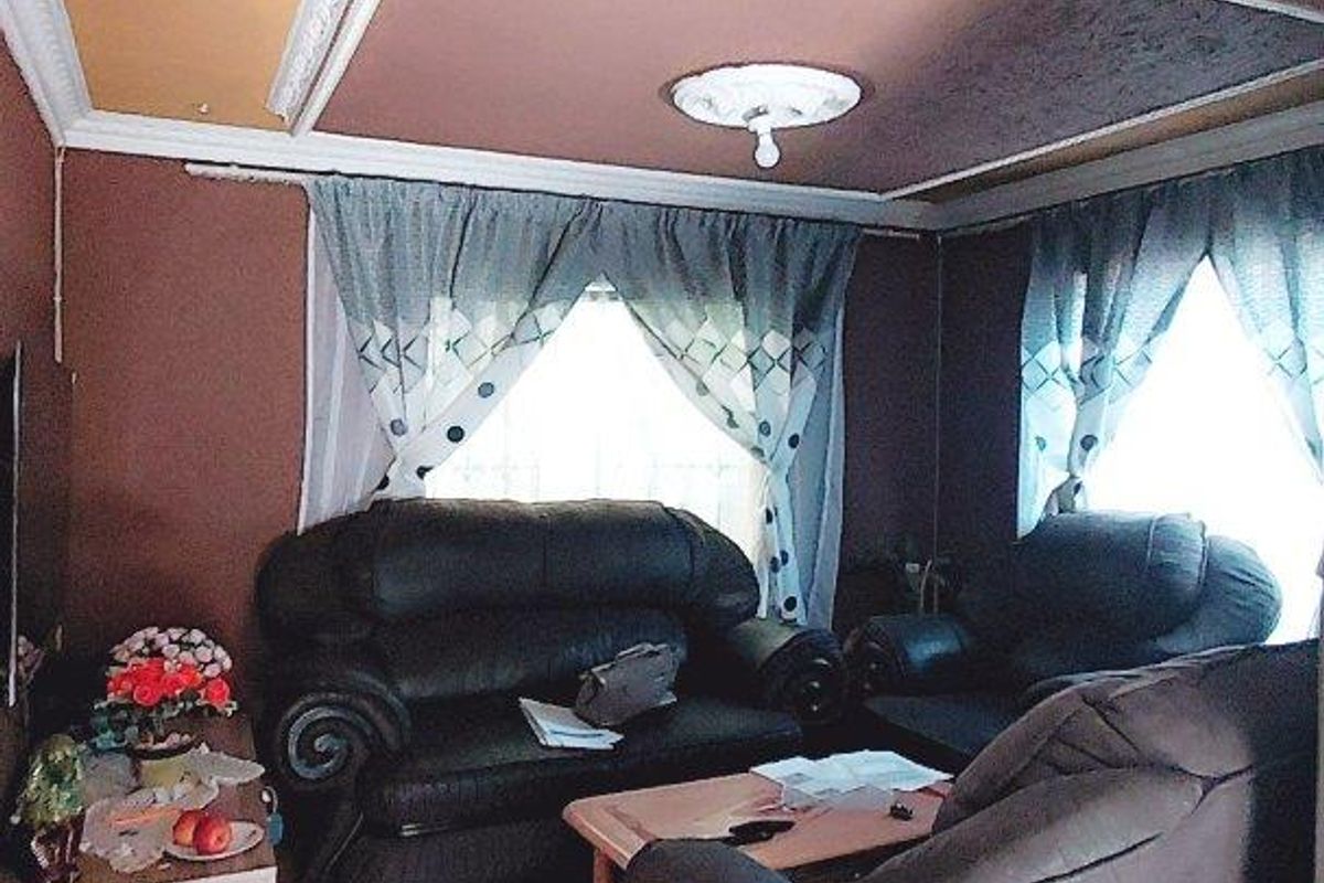 A living room featuring a recessed ceiling with decorative molding, a central ceiling rose, and ceramic floor tiles.
