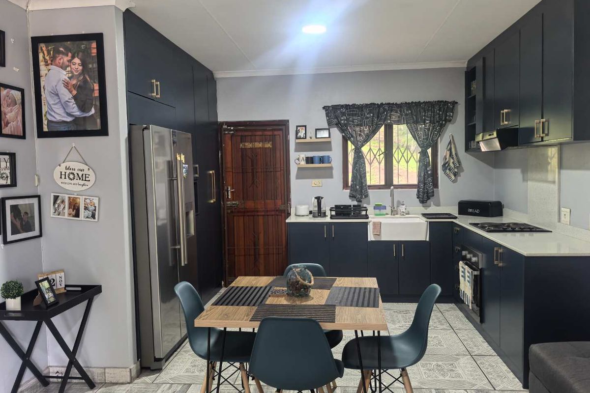 Modern kitchen featuring dark blue cabinetry, stone countertops, an apron front sink, and integrated appliances, creating a stylish and functional culinary space.