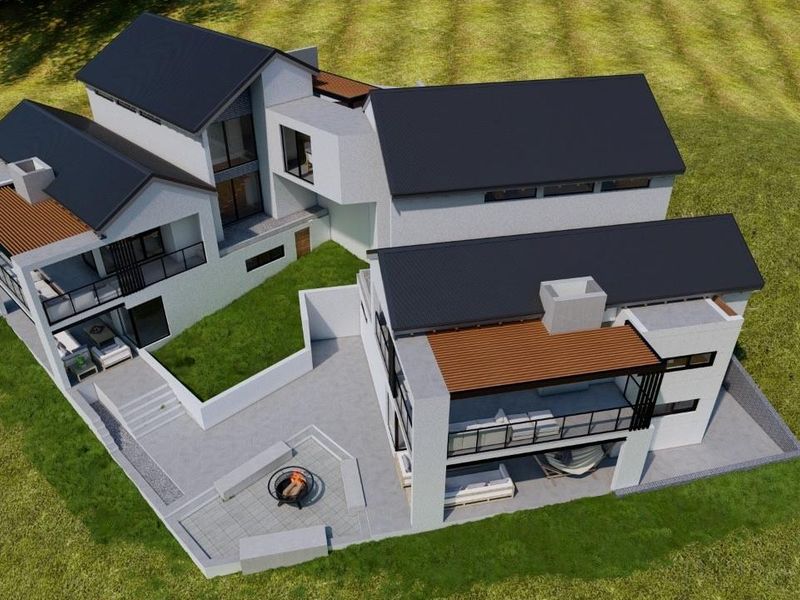 Aerial view of a modern multi-level residential property featuring pitched roofs, covered patios, and an outdoor fire pit area.