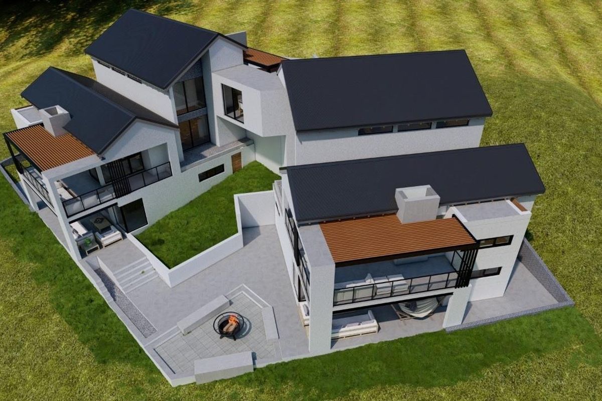Aerial view of a modern multi-level residential property featuring pitched roofs, covered patios, and an outdoor fire pit area.