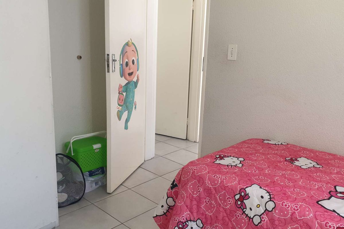 A bedroom featuring tiled flooring and a built-in closet with a door, providing functional living space within the apartment.