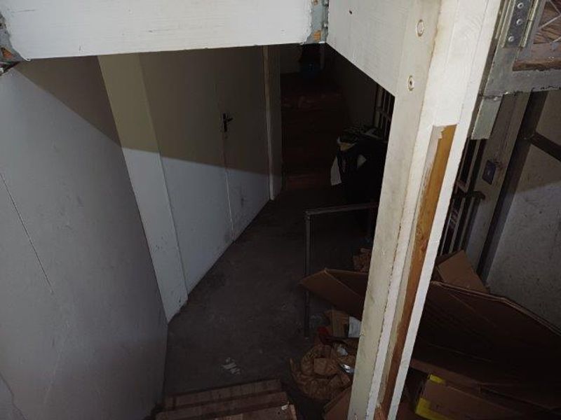 A dimly lit, utilitarian stairwell area showing signs of wear and requiring maintenance.