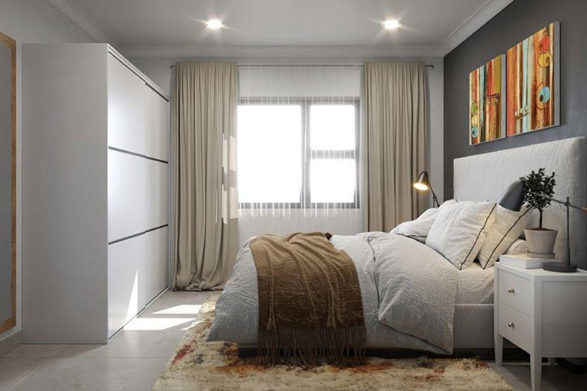 A well-appointed bedroom featuring a large built-in wardrobe, neutral tiled flooring, and recessed ceiling lighting, creating a modern and comfortable living space.