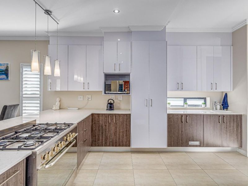 Modern kitchen featuring dual-tone cabinetry, quartz countertops, a gas cooktop, built-in oven, and high-quality finishes throughout.