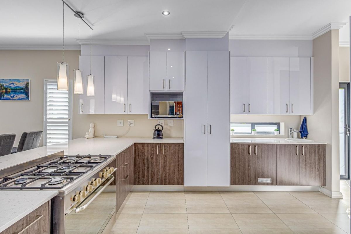 Modern kitchen featuring dual-tone cabinetry, quartz countertops, a gas cooktop, built-in oven, and high-quality finishes throughout.