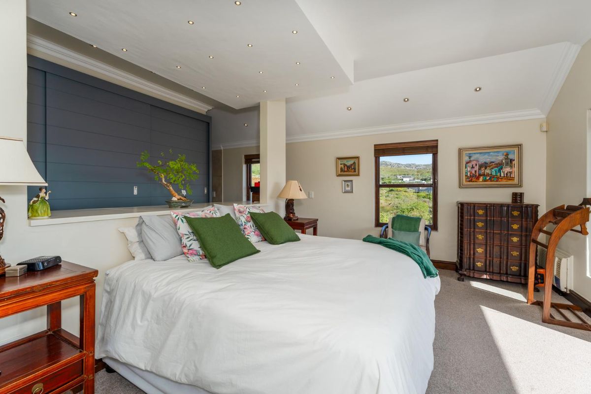 Spacious bedroom featuring a vaulted ceiling with recessed lighting, neutral carpeting, and a large window offering scenic views.