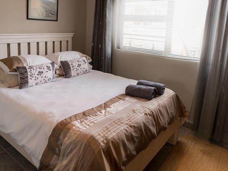 A well-maintained bedroom featuring tiled flooring and window blinds, offering a comfortable and functional living space.