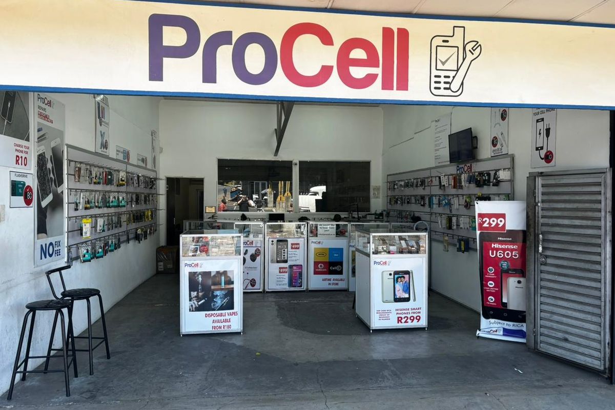 A retail storefront interior featuring fixed display counters and wall-mounted shelving for mobile accessories and repair services.