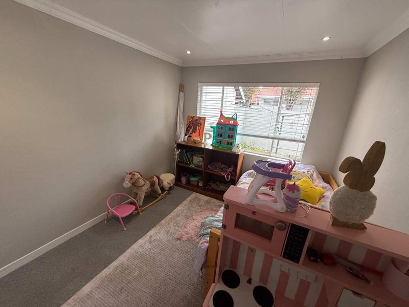 A bedroom featuring neutral wall paint, carpeted flooring, recessed downlighting, and a window with fitted blinds.