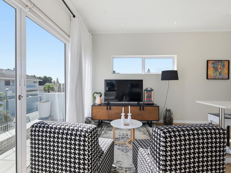 Bright living room featuring large sliding glass doors that provide ample natural light and access to an outdoor balcony area.