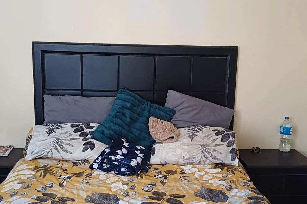 A bedroom featuring a built-in headboard and matching bedside pedestals, providing a functional sleeping space.