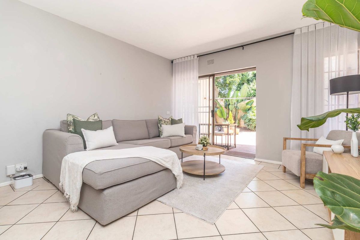 Bright living room featuring ceramic floor tiles and sliding glass doors providing direct access to a private patio area.