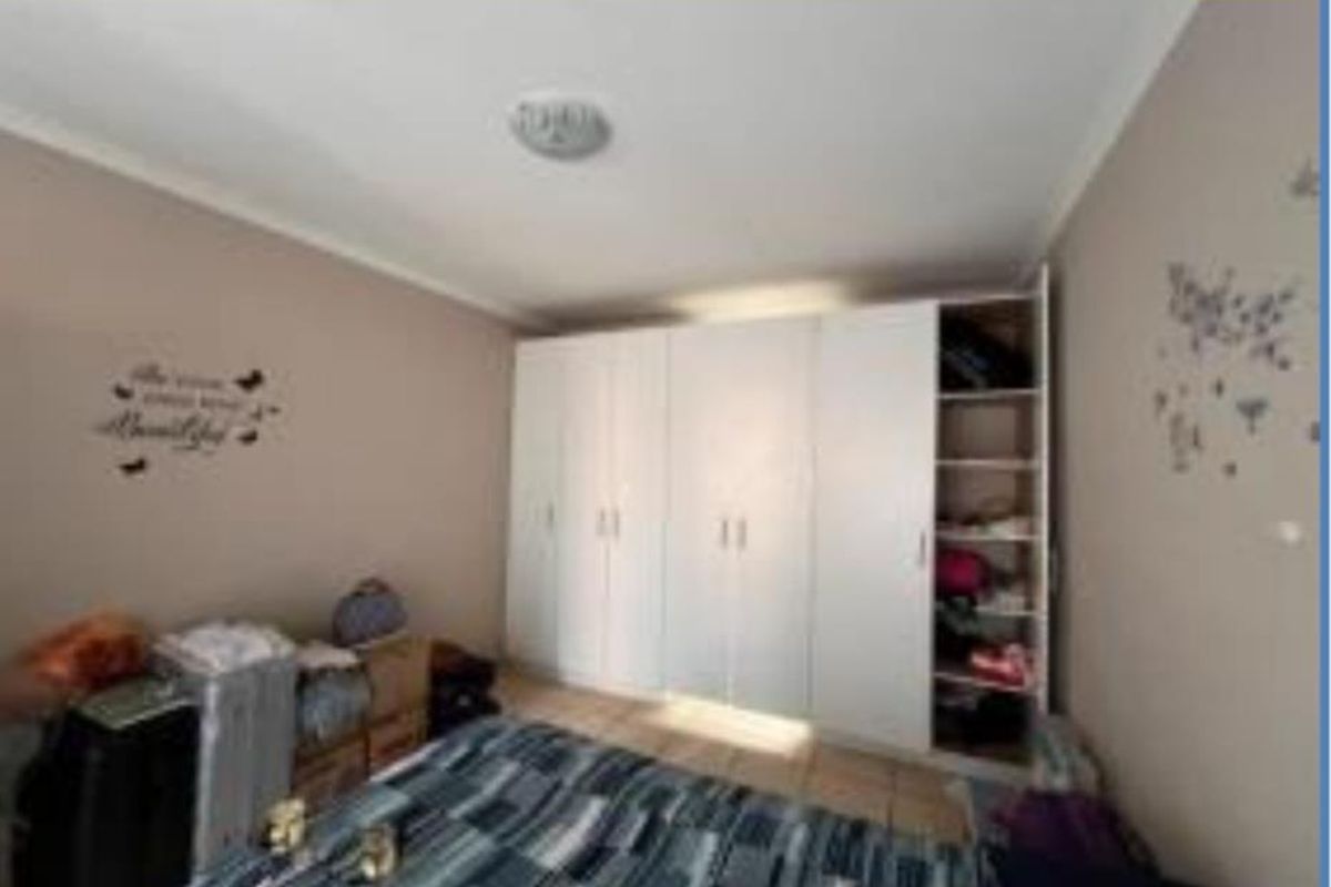 A bedroom featuring built-in white cabinetry providing ample storage space.