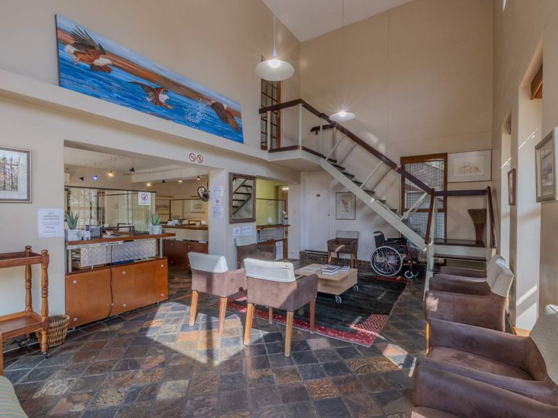 Spacious entrance foyer featuring high ceilings, a staircase, slate tile flooring, and a built-in reception counter area.