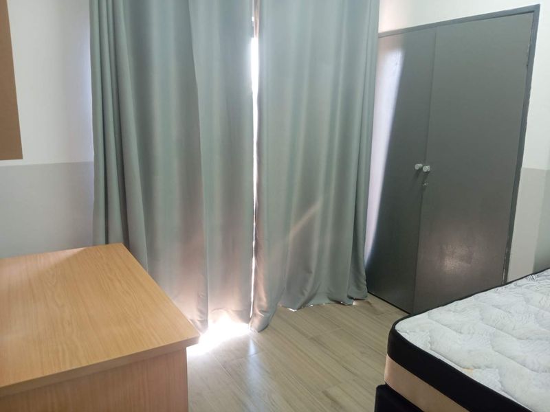 A bedroom featuring laminate flooring and a built-in wardrobe, with natural light entering through the window area.