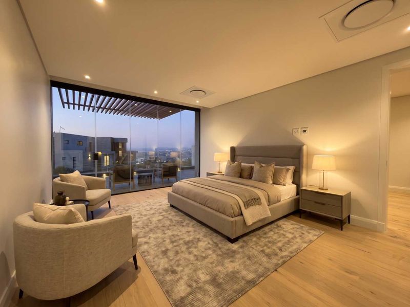 Spacious modern bedroom featuring hardwood flooring, recessed lighting, and expansive floor-to-ceiling glass doors opening to a private balcony with scenic views.
