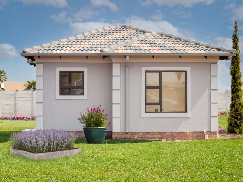 A well-maintained single-story residential structure featuring a tiled roof, neutral exterior walls, and modern aluminium window frames set within a landscaped garden.