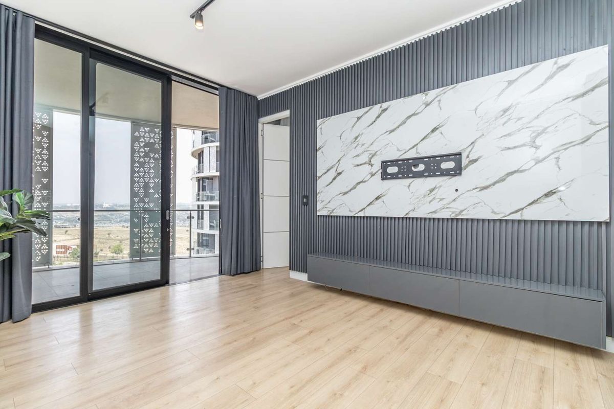 Modern living room featuring stylish slatted wall paneling, a marble-look feature wall with built-in media console, and large sliding doors leading to a balcony.