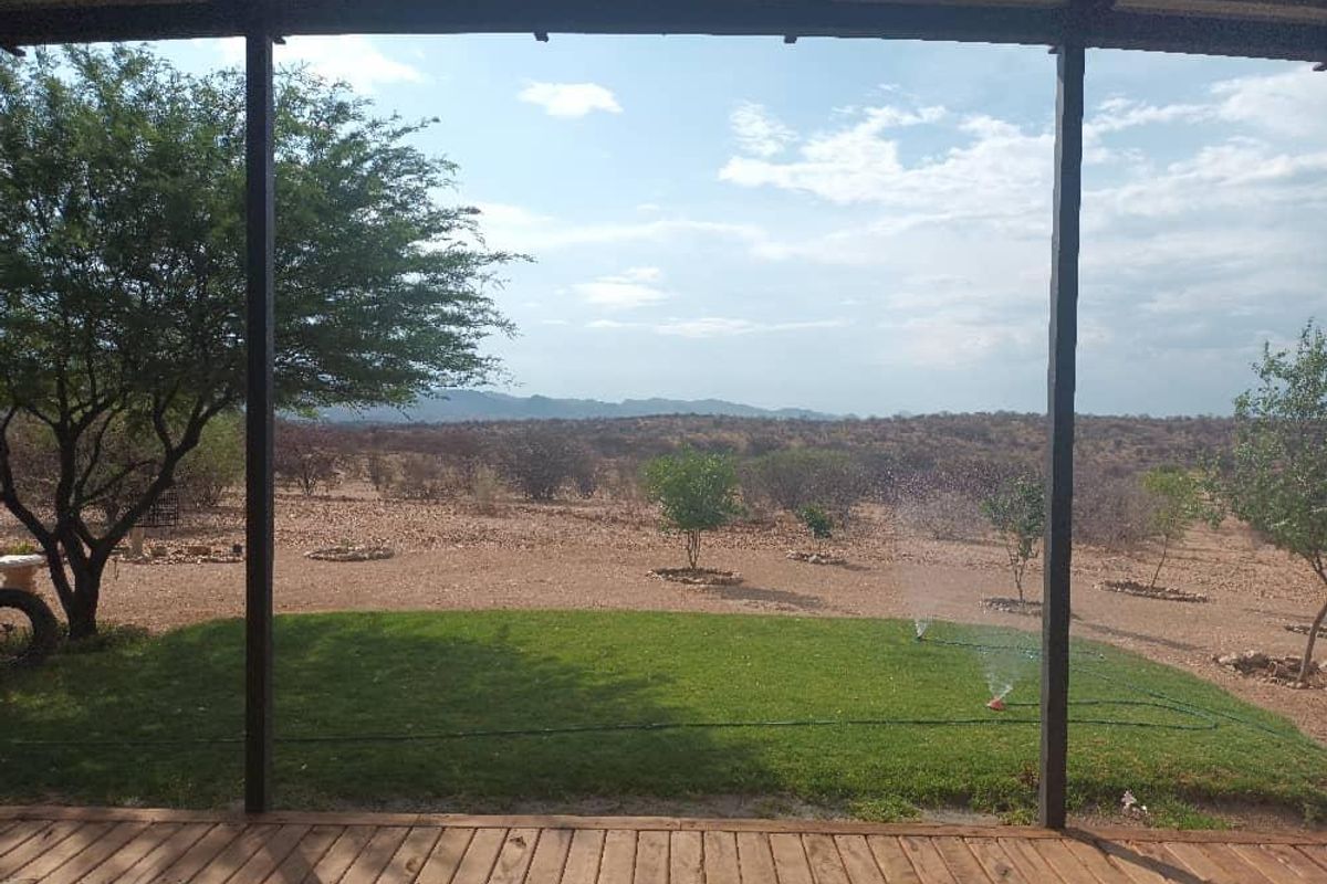 A covered timber deck patio offering expansive views over the surrounding landscape and garden area.