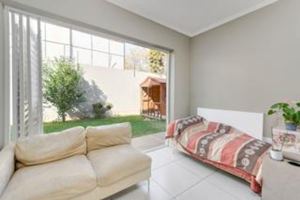 Bright living room featuring large sliding glass doors that provide seamless access to the private garden area.