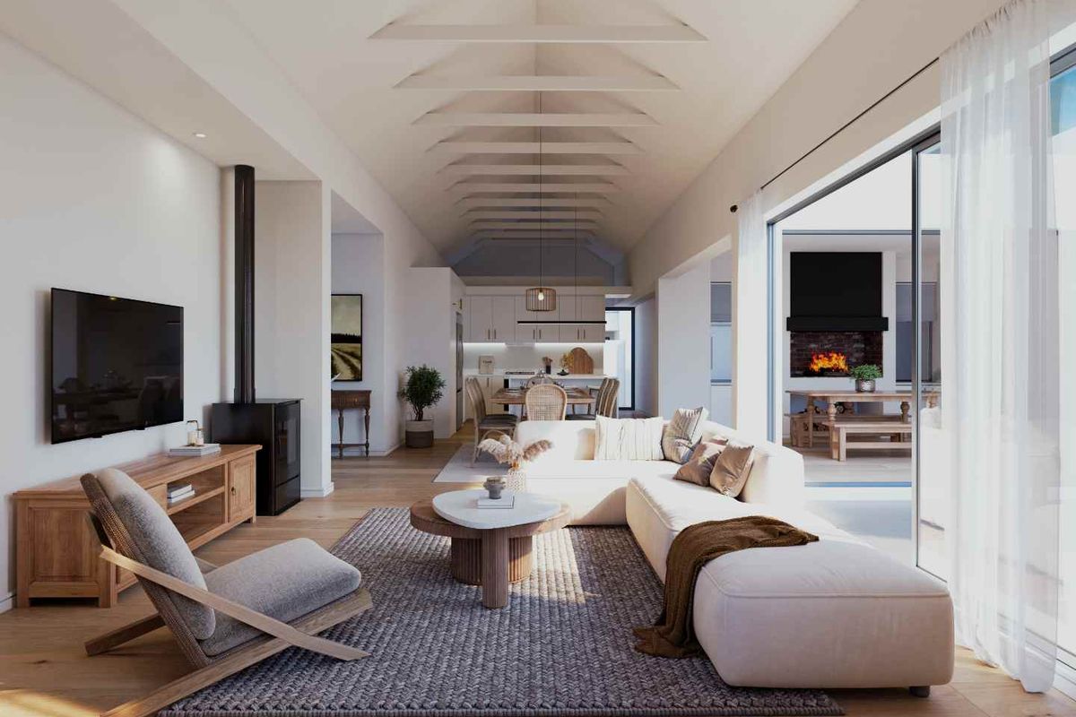 Spacious open-plan living and kitchen area featuring a dramatic vaulted ceiling with exposed rafters, wood burning stove, and seamless flow to the outdoor patio.