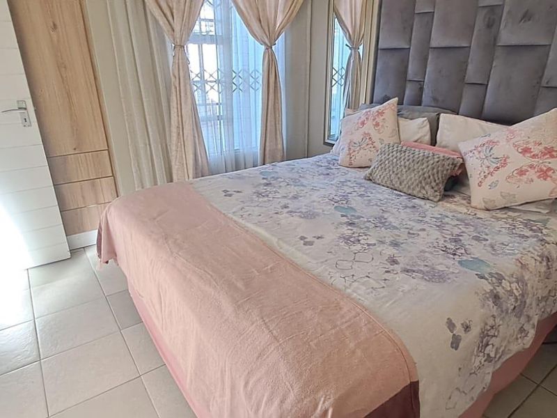 A well-maintained bedroom featuring tiled flooring, built-in cupboards, and a security gate on the window.