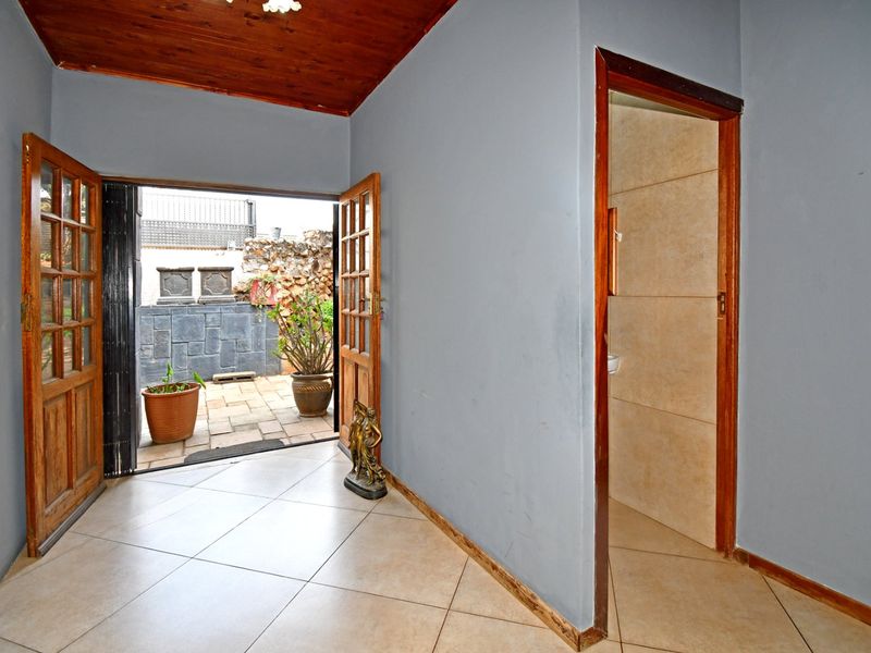 Entrance hall featuring tiled flooring, timber ceiling, and direct access to an outdoor patio area.