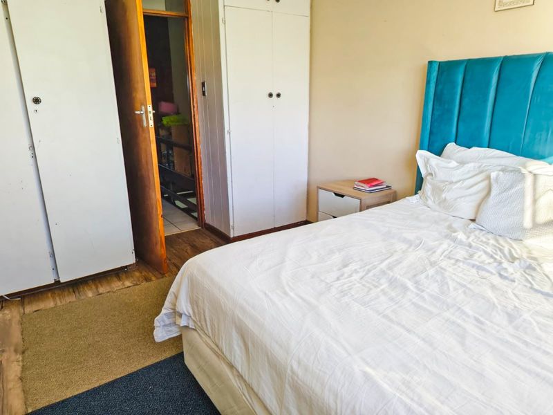 A bedroom featuring built-in cupboards and wooden flooring, offering a functional space with potential for cosmetic updates to enhance its appeal.