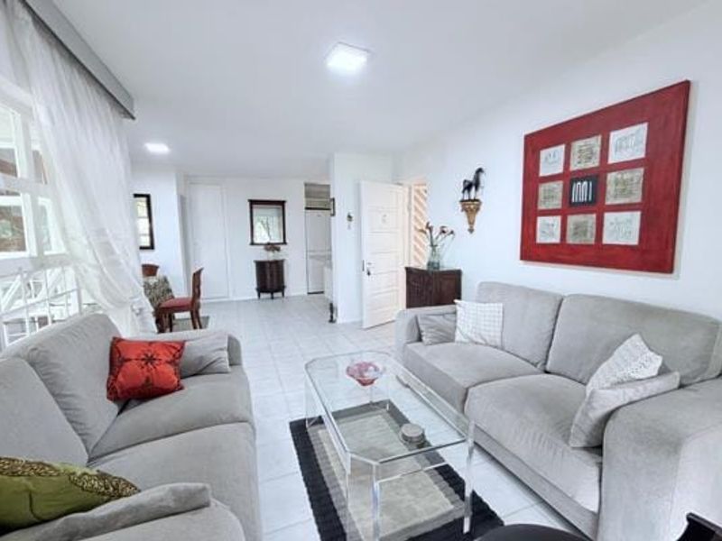 Open-plan living area featuring neutral tiled flooring, recessed lighting, and large windows, providing a bright and functional space for relaxation and dining.