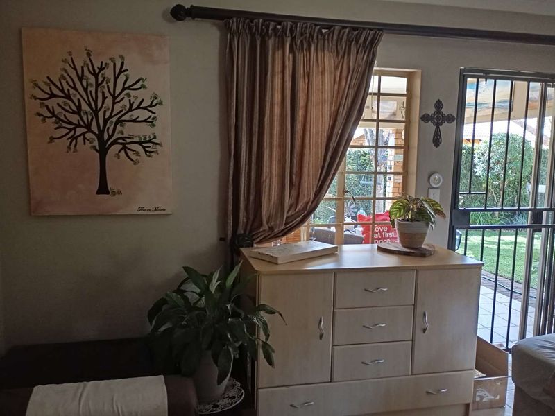 A living area featuring a window with security bars and a metal security gate leading to the exterior.