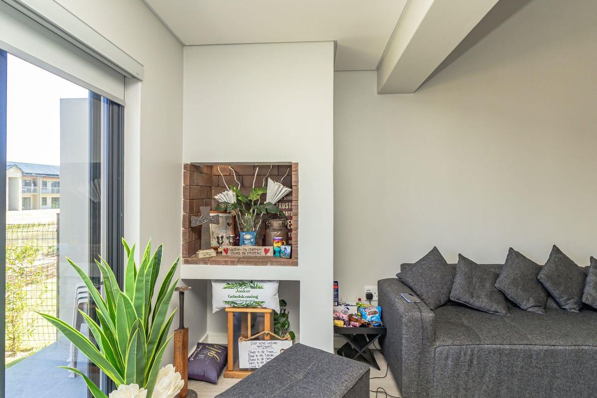 A bright living area featuring a built-in brick fireplace and large sliding glass doors providing access to the outdoor space.