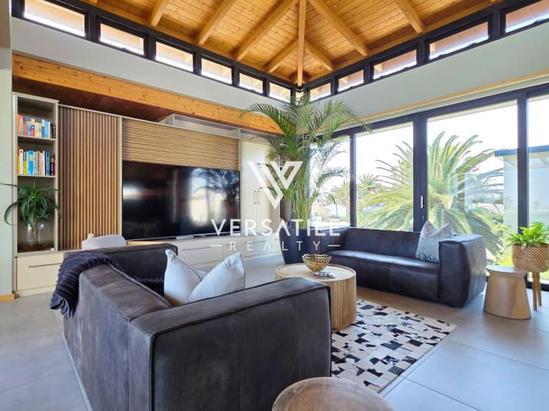 Spacious living room featuring a striking exposed timber vaulted ceiling, clerestory windows, and large sliding glass doors that provide abundant natural light.