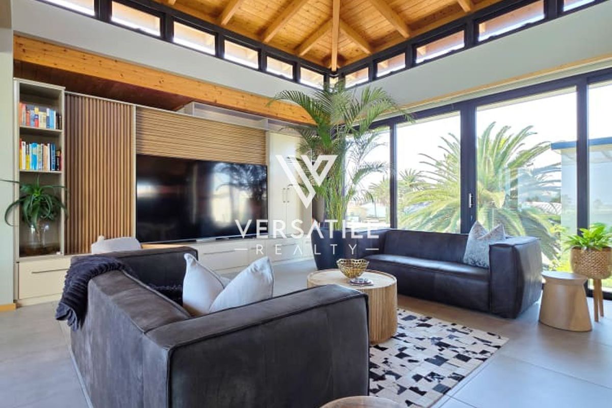 Spacious living room featuring a striking exposed timber vaulted ceiling, clerestory windows, and large sliding glass doors that provide abundant natural light.