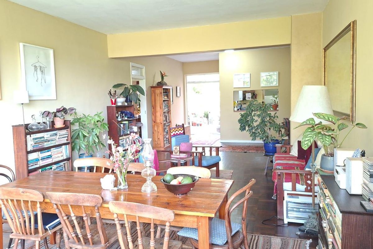 Spacious open-plan living and dining area featuring warm hardwood flooring and a seamless flow towards the rear of the apartment.