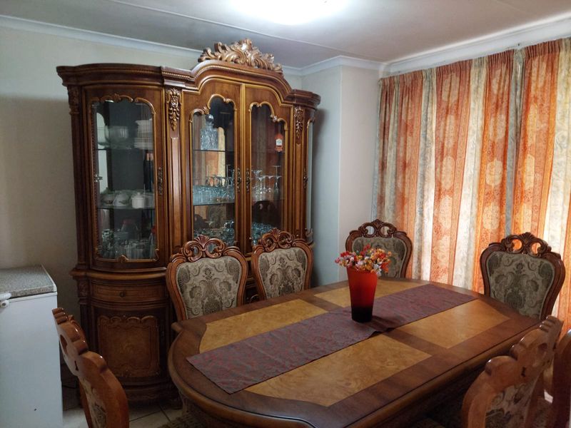 A traditional dining room featuring tiled flooring and decorative coving, providing a formal space for family meals and entertaining.