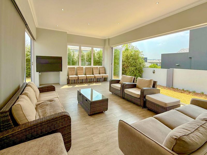 Spacious covered patio featuring tiled flooring, recessed downlighting, and large bi-fold doors that open to the garden area.