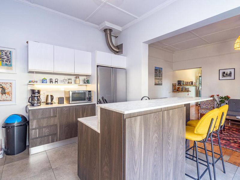 Modern open-plan kitchen featuring sleek cabinetry, stone countertops, and a functional island, seamlessly flowing into the adjacent living area.